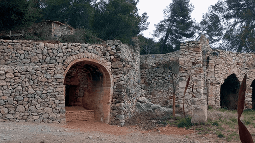 En primer pla, el forn de calç restaurat recentment, a l'esquerra, els altres dos forns de la façana sud.